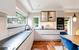 a kitchen with white cabinets and a wooden table at Private holiday home near Pärnu and Lottemaa in Pärnu