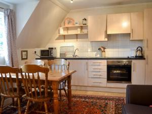 a kitchen with a wooden table and chairs in a room at Hawthorn in Llanddona