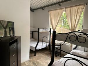 a bedroom with two bunk beds and a tv and a window at Finca de descanso Brisas de Calandaima in Viotá +53 photos