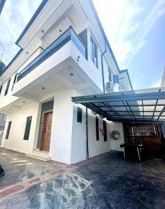 a large white building with a staircase on it at EliteunseenSuites - 5 Bedroom Beautiful Detached House - Private Parking in Lekki