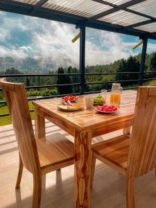 - une table en bois avec de la nourriture et des boissons sur une terrasse dans l'établissement Apartamento en Guarne-Antioquia, à Guarne