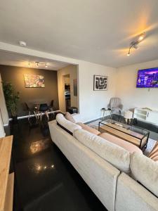 a living room with two couches and a tv at 5 STATE FAIR l DT Dallas l FIFA READY l Staycation 1Bd1Ba in Dallas