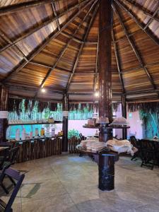 a large wooden pavilion with a table and chairs at Mambuca Village in Ubatuba