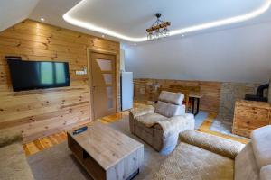 een woonkamer met houten wanden en een flatscreen-tv bij Apartman Filip in Kolašin