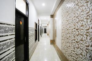 a hallway with a wall covered in ornate art at Hotel O Devi Palace Inn in Gurgaon