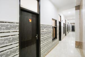 a hallway with black doors in a building at Hotel O Devi Palace Inn in Gurgaon