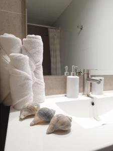 two seashells sitting on a bathroom sink with towels at NM Departamentos Amoblados in Concepción