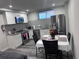 a kitchen with a table with chairs and a refrigerator at Elegant Cozy Private Apartment in Calgary