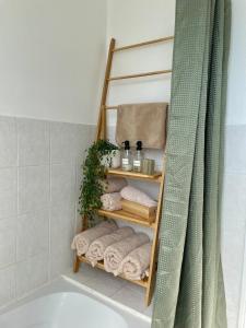 a bathroom with a towel rack next to a bath tub at L'escapade de saint Antoine in Compiègne