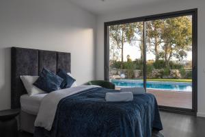 1 dormitorio con 1 cama grande y piscina en Silver Coast Luxury Villa, en Reguengo Grande
