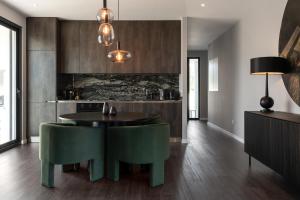 cocina con mesa y 2 sillas verdes en Silver Coast Luxury Villa, en Reguengo Grande