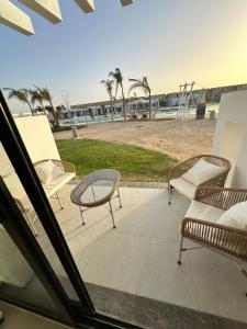 eine Terrasse mit Stühlen und Strandblick in der Unterkunft Sea View Studio Apartment in Zāwiyat ‘Abd al Mun‘im