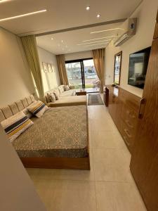 ein Schlafzimmer mit zwei Betten und einem Flachbildfernseher in der Unterkunft Sea View Studio Apartment in Zāwiyat ‘Abd al Mun‘im