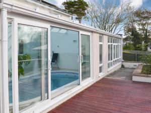 un salón acristalado con puertas correderas de cristal en una casa en Riverside, en Bude 3 fotos más