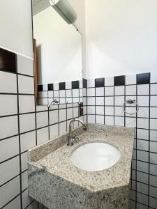 a bathroom with a sink and a mirror at Hotel Cores do Mar in Bombinhas +12 photos