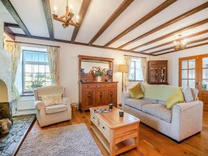 ein Wohnzimmer mit Sofa und Tisch in der Unterkunft Penyrorsedd Cottage in Llanfachraeth