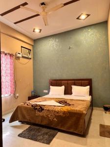 um quarto com uma cama com uma parede verde em Raghav dham em Vrindāvan