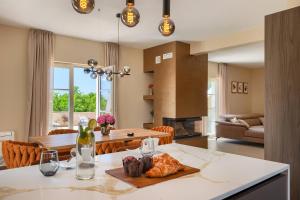 a kitchen and living room with a table and a couch at Villa Bel Fiore in Sveti Lovreč Pazenatički