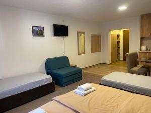 a hotel room with two beds and a blue chair at 4 vodenice Brzeće B&B in Brzeće
