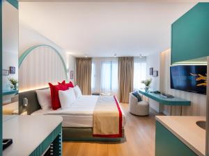 a hotel room with a large bed with red pillows at Taksim Juno Residences in Istanbul