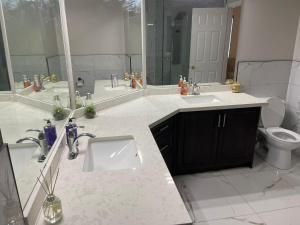 a bathroom with two sinks and a toilet at Grandeur Homes in Whitby +13 photos