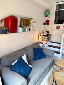 a living room with a gray couch with blue pillows at Joli maison de pêcheur à 50m de la plage en plein centre in Étretat