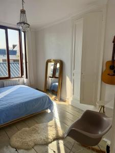 a bedroom with a bed and a mirror and a chair at Joli maison de pêcheur à 50m de la plage en plein centre in Étretat