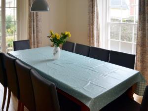 una mesa azul con un jarrón con flores amarillas. en Hawkins, en Dartmouth