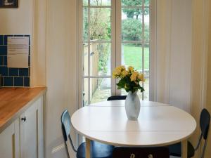 Una mesa blanca con un jarrón de flores. en Hawkins, en Dartmouth