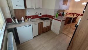 a small kitchen with white appliances and wooden cabinets at Hunyadi Luxury Ciresica in Sibiu