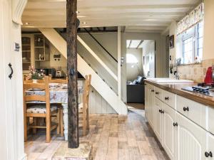 a kitchen with a table and a dining room at Beehive Cottage in Wittersham
