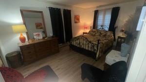 a bedroom with a bed and a dresser and a mirror at Paradise Eastern Township cottage in Cowansville