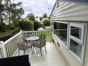 een terras met een tafel en stoelen op een dek bij Lovely 8 Berth Caravan At Southview Holiday Park, Skegness Ref 33023M in Skegness