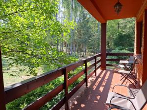 a porch with two chairs and a view of the woods at Dom Wakacyjny z ogromnym ogrodem in Witaszyn +28 photos
