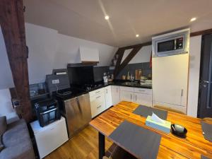 a kitchen with a wooden table and a stove top oven at Historic Canal-Side Apartment in Schiedam