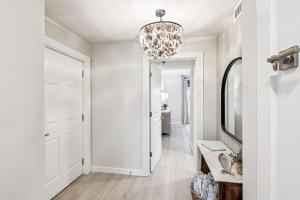 a hallway with a white door and a chandelier at Tranquillity on 30A Unit# 210 by 30A Escapes in Seacrest