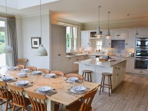 cocina con mesa de madera con sillas y comedor en Treburthick House, en Charlestown