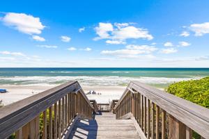 a wooden staircase leading to a beach with the ocean at Tranquillity on 30A Unit# 210 by 30A Escapes in Seacrest
