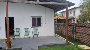 Tres sillas verdes sentadas en un patio al lado de una casa en Praiana, en Belém