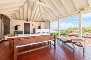 an open kitchen with a bench and a table at Atea, le Loft... un concept saintois original in Terre-de-Haut