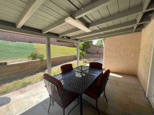 a patio with a table and chairs on a porch at Beautiful and cozy! in Palmdale