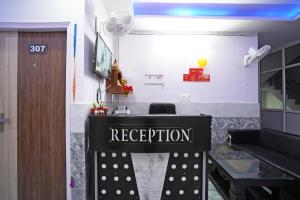 a reception desk with a sign in a room at Hotel O Plus One Hotel Residency in New Delhi