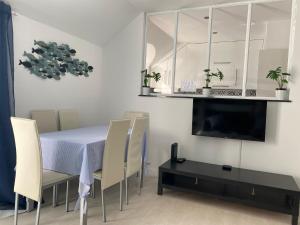 une salle à manger avec une table et des chaises et une télévision dans l'établissement Blue Beach Home with Terrace, à Albufeira
