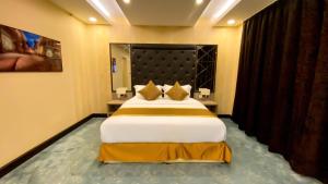 Un dormitorio con una cama grande en una habitación. en Al Maali Hotel Jazan, en Jazan