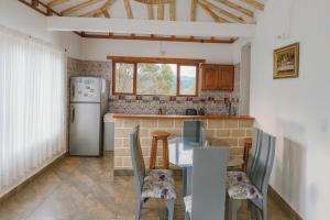 a kitchen with a table and chairs and a refrigerator at Cabaña familiar con 4 dormitorios y baños privados in Villa de Leyva