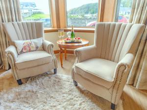 two chairs in a living room with a table at Blair Terrace in Portpatrick