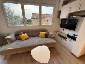 un salon avec un canapé et deux fenêtres dans l'établissement Spacious 2 bedroom Apartment near Marina by Solea Homes, à Tivat