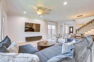 Una sala de estar con un sofá azul y una mesa. en Pet-Friendly Duplex Unit in Southwest Houston, en Houston