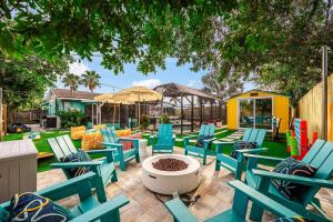a patio with blue chairs and a fire pit at Heated Pool, Mini Golf, Arcade, Spa, AMI 6mi, IMG 3mi in Bradenton