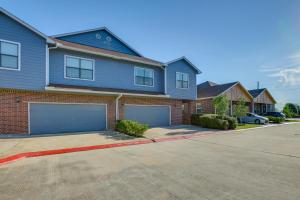 una casa azul con dos puertas de garaje en una calle en Pet-Friendly Duplex Unit in Southwest Houston, en Houston